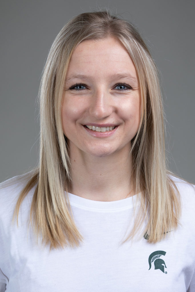 Headshot of a woman with blonde hair and blue eyes smiling.