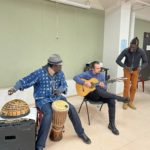 Person playing drums and person playing guitar