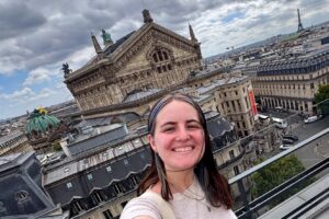 Woman taking a selfie with the city of Paris in the background.