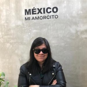 Prof. Marquez stands beneath a graffiti sign reading "Mexico mi amorcito"