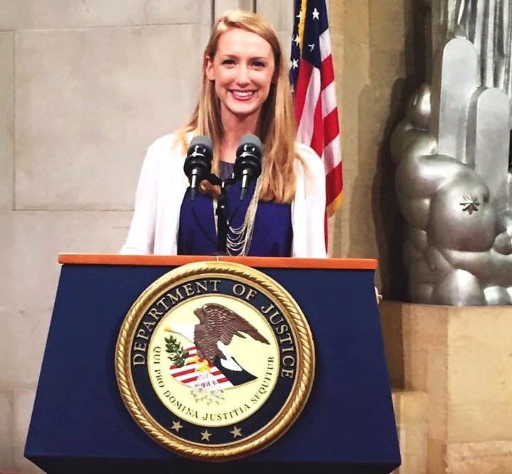 Portrait of Lauyren Haight standing in front of a United States Department of Justice podium.. 