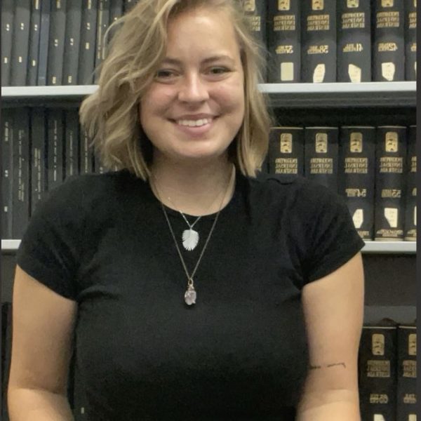 Young Woman Standing in Front of Bookcase